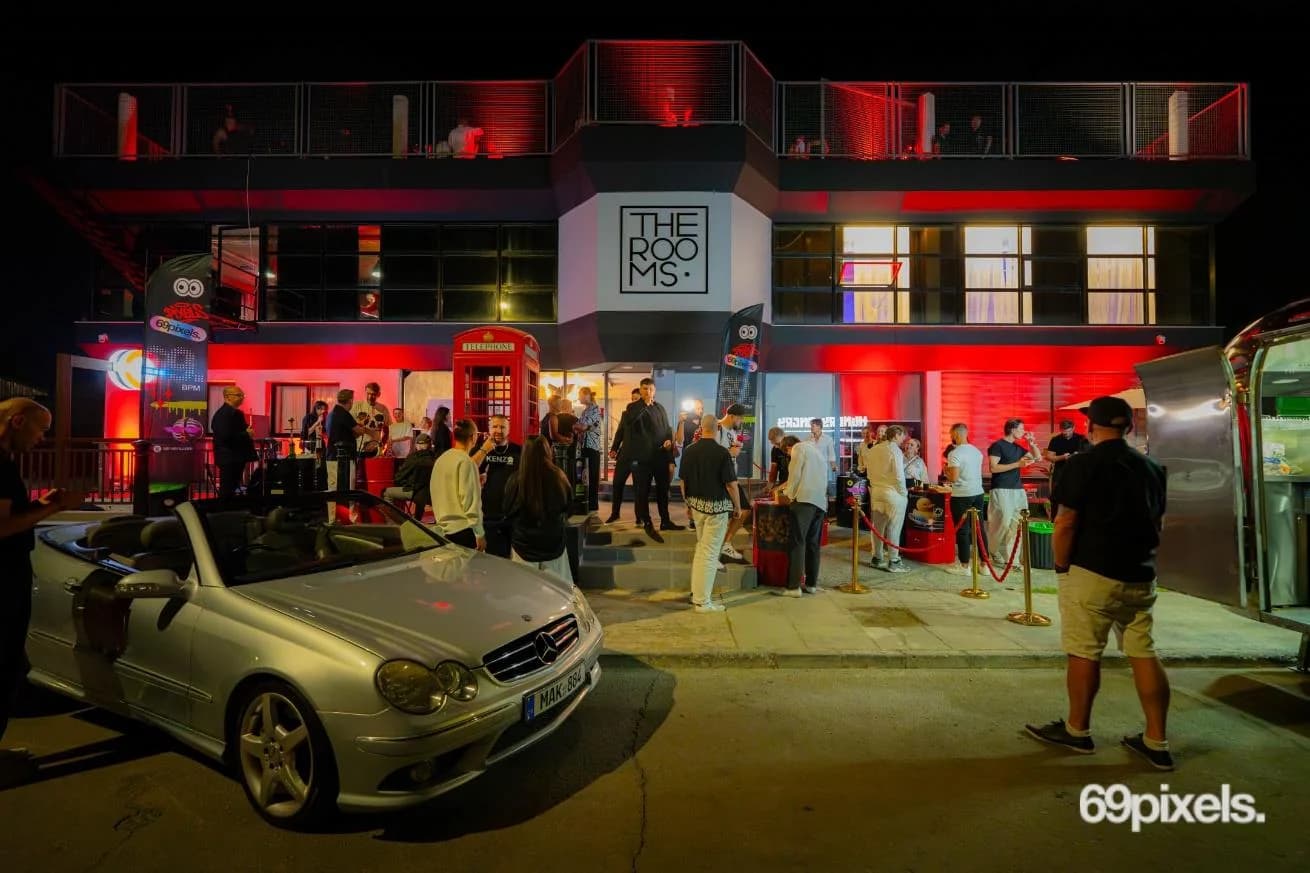 THE ROOMS building at night, lit red, with guests arriving for the masquerade and a red phone box by the door